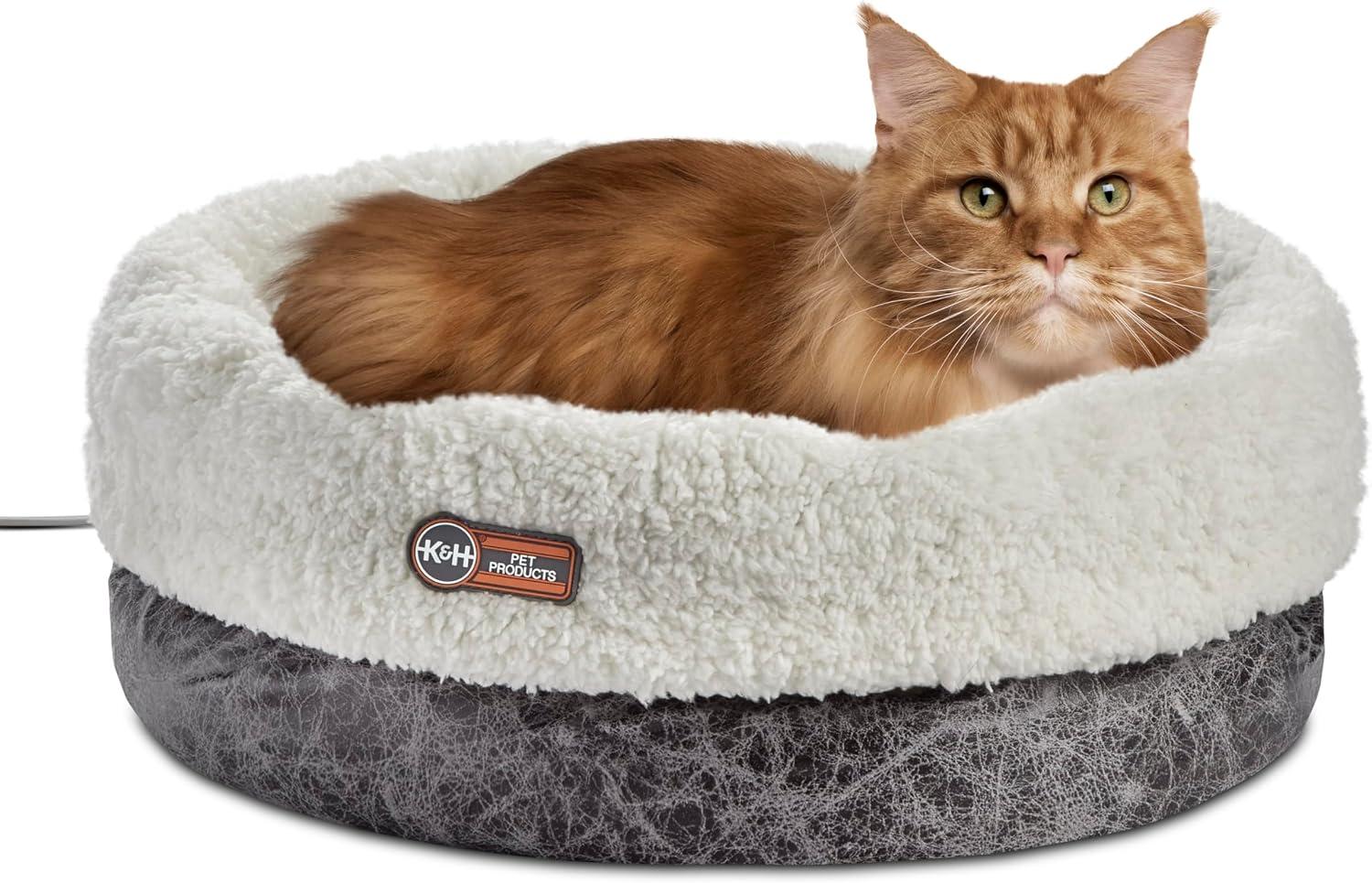 Round fleece heated indoor cat bed with padded bolster walls.